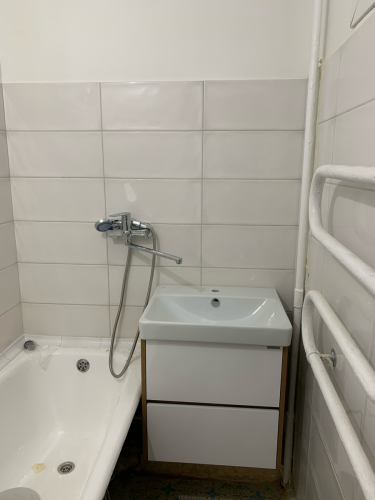 В ванной комнате установлено зеркало над раковиной. Закреплено надежно, без видимых крепежей. Поверхность ровная, отражение четкое. Подходит к интерьеру, добавляя свет и пространство.