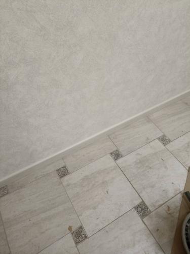 Установлен новый плинтус вдоль стены, аккуратно закреплённый, стыки ровные, без зазоров. Завершённый вид, гармонично сочетается с полом и стенами, создавая завершённый интерьер.