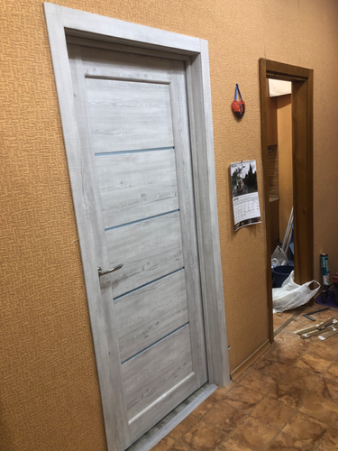 Установлена новая деревянная дверь с ручкой и петлями, произведена регулировка, выполнена отделка проема наличниками, обеспечена плавная работа, завершена чистовая отделка.