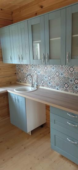 Установлены шкафы, прикреплена столешница, вмонтирована раковина, подключен смеситель, закреплены ручки, оформлен фартук плиткой, выровнены фасады, завершена сборка гарнитура.