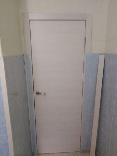 Установлены декоративные планки вокруг дверного проема, обеспечивая аккуратный и завершенный вид. Элементы плотно прилегают, создавая гармоничный переход между стеной и дверью.