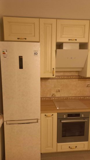 Установлены шкафы, закреплена столешница, вмонтирована техника, подключена вытяжка, выровнены фасады, установлены ручки, завершена отделка стен плиткой.