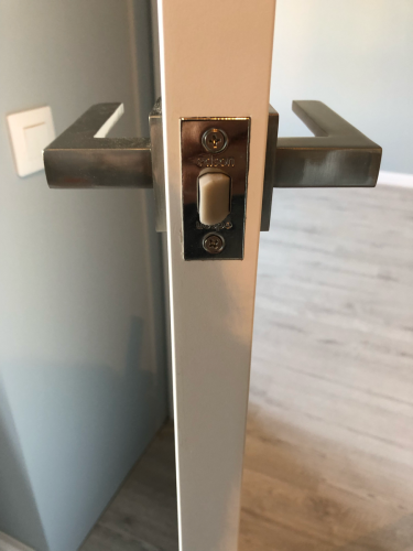 В деревянную дверь аккуратно встроен замок с ручкой. Выполнено точное сверление, установка механизма, закрепление крепежа. Все элементы надежно зафиксированы, функционируют исправно.