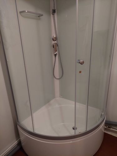 Установлена современная душевая конструкция с низким основанием. Подключены водопроводные элементы, закреплены стеклянные панели, герметизация швов завершена, проверена функциональность.