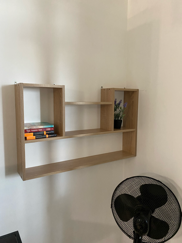 На стене закреплена деревянная конструкция с тремя секциями. Полка надежно установлена, выдерживает книги и декор. Работа выполнена аккуратно, без видимых дефектов.