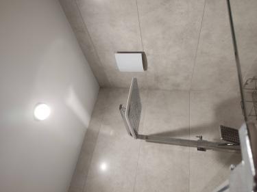 Установлена вентиляционная решетка на стене ванной комнаты, обеспечивающая свежий воздух и улучшенную циркуляцию. Завершены все работы по подключению и закреплению системы.