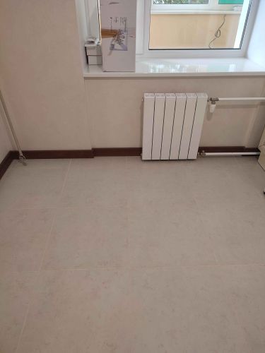 Установлен новый напольный плинтус, аккуратно прилегающий к стенам и полу. Завершены все работы по монтажу, обеспечена ровная линия и плотное прилегание.