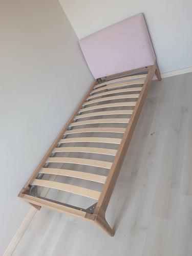 Собрана конструкция кровати: установлено изголовье, закреплены боковые панели, уложены ламели на каркас. Все элементы надежно соединены, обеспечивая устойчивость и прочность.