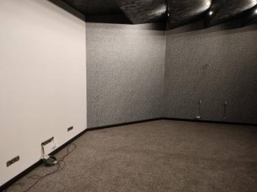 На полу ровно постелен ковролин, аккуратно подогнанный по краям. Швы тщательно скрыты, обеспечивая гладкую поверхность. Углы оформлены безупречно, создавая цельный вид.