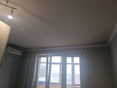 Установлен декоративный элемент между стеной и потолком, аккуратно закреплен по периметру комнаты, создавая завершенный вид интерьера.