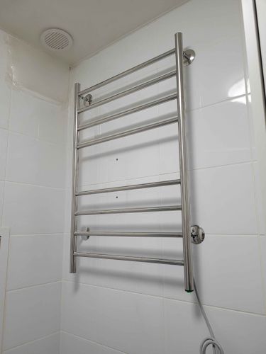 Закреплен металлический прибор на стене, подключен к электросети, проверена работоспособность, скрыт провод, обеспечена безопасность, завершена установка в ванной комнате.