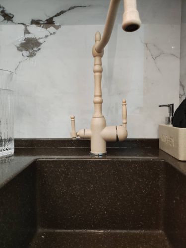 На изображении представлен установленный новый кухонный кран. Выполнены монтажные работы, подключены водопроводные трубы, проверена герметичность соединений, обеспечена функциональность устройства.