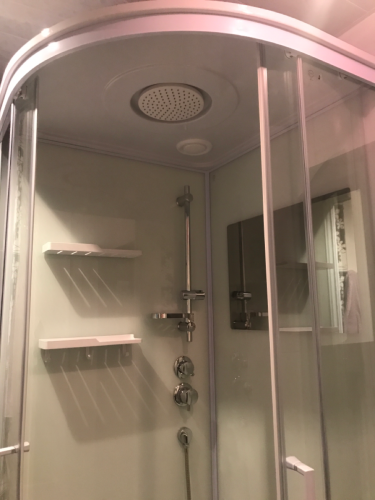 Установлена современная душевая конструкция с герметичными стенками и дверцами, смонтированы полки для удобства, подключены смеситель и лейка, обеспечено надежное уплотнение и водоотведение.