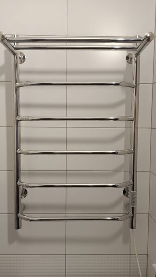 Установлен электрический полотенцесушитель на стену, подключен к сети, проверена работоспособность, закреплен надежно, обеспечена безопасность использования.