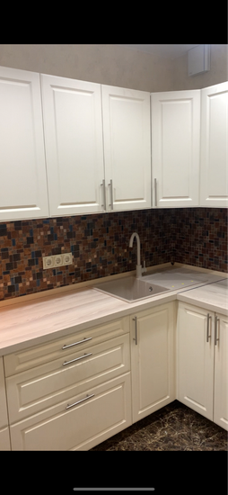 На кухне установлена новая столешница, выполнены точные вырезы для мойки и варочной панели. Все элементы аккуратно подогнаны, обеспечивая плавный переход и гармоничный вид.