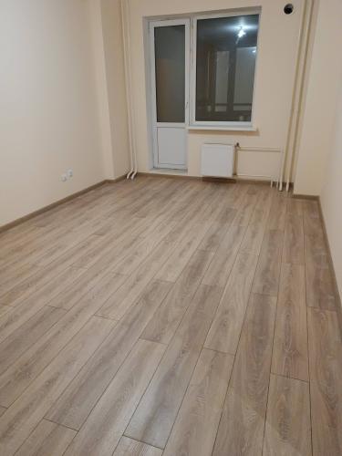 В комнате уложено новое покрытие, ровно и аккуратно, без зазоров. Пол выглядит современно и стильно, создавая уютную атмосферу. Завершение работы придаёт помещению свежий вид.