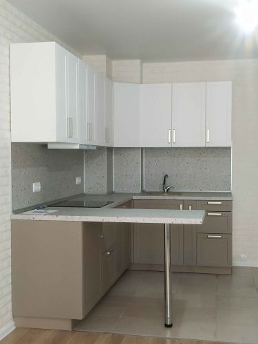 Отрезана и установлена кухонная поверхность с точной подгонкой, вырезаны отверстия для варочной панели и мойки, закреплены опоры, обеспечена ровная стыковка с мебелью.