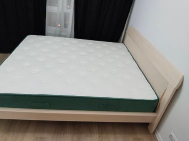 Собрана двуспальная кровать: установлено изголовье, закреплены боковые панели, уложено основание, размещён матрас. Работа завершена, мебель готова к использованию.