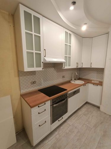 Установлены шкафы, закреплены фасады, смонтирована столешница, подключена варочная панель, врезана мойка, установлены ручки, выполнена подгонка элементов, завершена отделка стен.