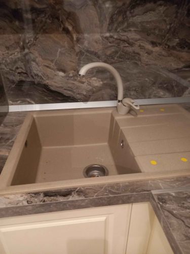Установлено отверстие для мойки в кухонной поверхности из камня. Выполнена точная подгонка и монтаж, обеспечивающие надежное соединение и эстетичный вид.