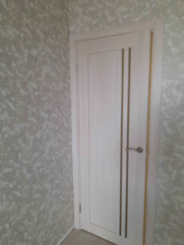 На деревянной двери выполнена установка замка: проделано отверстие, закреплён механизм, установлены ручки. Все элементы аккуратно подогнаны, обеспечена плавная работа.