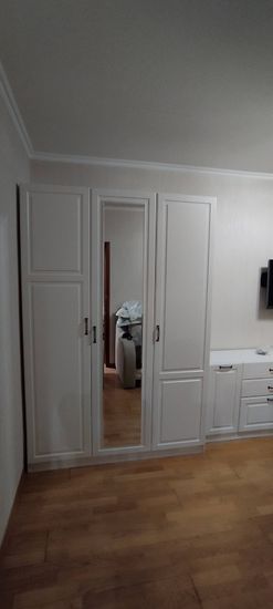 Собран шкаф с дверцами, зеркалом и ручками. Установлены полки, ящики и крепления. Все элементы соединены, обеспечена устойчивость и функциональность конструкции.