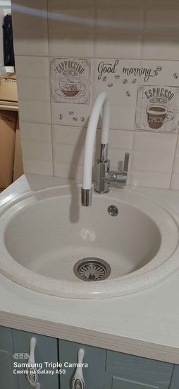 Выполнена установка мойки в кухонную поверхность, вырезано отверстие для раковины, произведен монтаж смесителя. Завершена подгонка и герметизация краев для надежности.