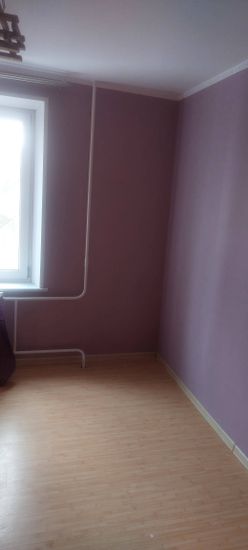 Стены оклеены фиолетовыми обоями, швы аккуратные, поверхность ровная. Углы и стыки обработаны, все элементы гармонично сочетаются, создавая уютную атмосферу в комнате.