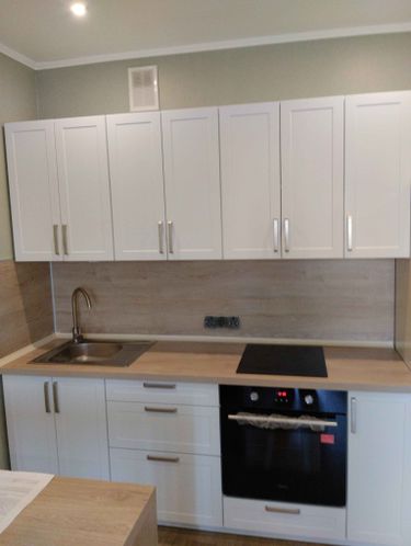 Установлены шкафы, смонтирована столешница, встроена варочная панель и мойка. Подключены коммуникации, закреплены фасады и ручки. Завершена отделка стен и потолка.