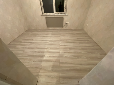 Покрытие уложено на подготовленное основание, доски плотно подогнаны, швы аккуратно стыкуются, поверхность ровная и гладкая, завершённая работа гармонично вписывается в интерьер.