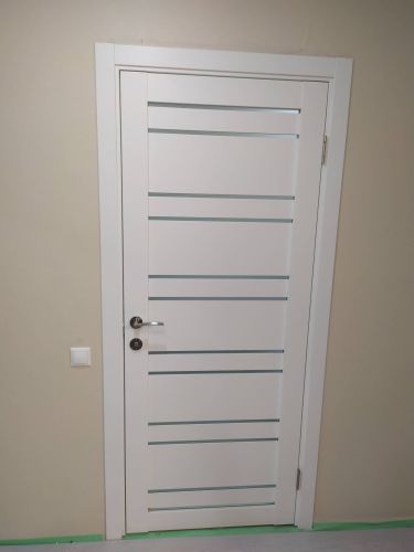 Установлена новая деревянная дверь с одной створкой, закреплены петли, врезан замок, отрегулирована фурнитура, проверена плавность открывания и закрывания, выполнена отделка проема.