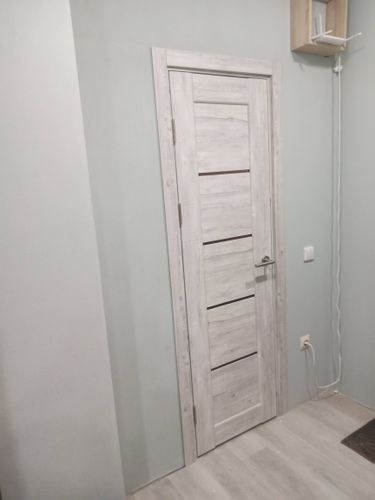 Установлена новая дверь с петлями и ручкой, закреплена в проеме, отрегулирована для плавного открывания и закрывания, обеспечена надежная фиксация и эстетичное оформление.