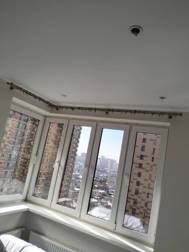 Установлен карниз для штор на потолке в углу комнаты. Закреплены крепления, выровнены элементы. Завершён монтаж, обеспечена надёжность конструкции.