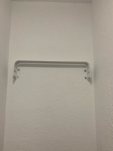 На стене закреплены кронштейны для установки зеркала. Поверхность подготовлена, крепежные элементы надежно зафиксированы, обеспечивая устойчивость и безопасность будущей конструкции.