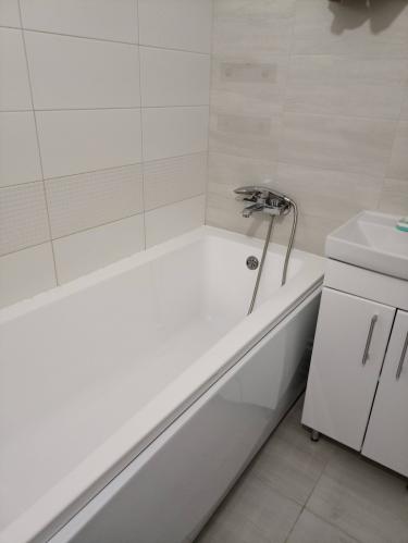 Установлена новая ванна, подключены смеситель и слив, герметично заделаны стыки, проверена система на утечки, выполнена облицовка плиткой, обеспечена устойчивость конструкции.