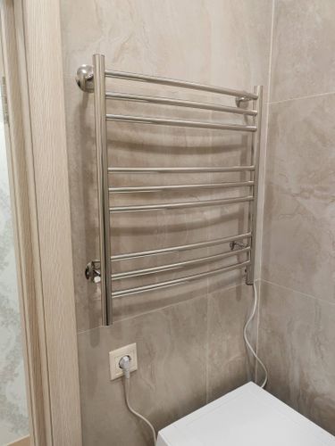 Установлен электрический полотенцесушитель: закреплен на стене, подключен к розетке, проверена работоспособность, обеспечена надежная фиксация, соблюдены меры безопасности.