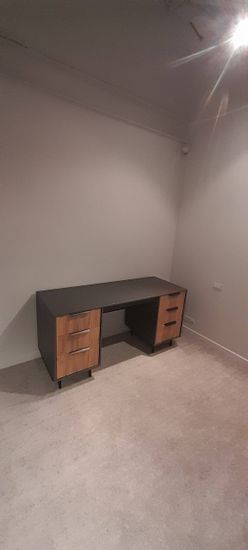 Собран шкаф с ящиками, установлены ручки, закреплены ножки, проверена устойчивость, выровнены фасады, проверена плавность выдвижения, завершена установка в комнате.