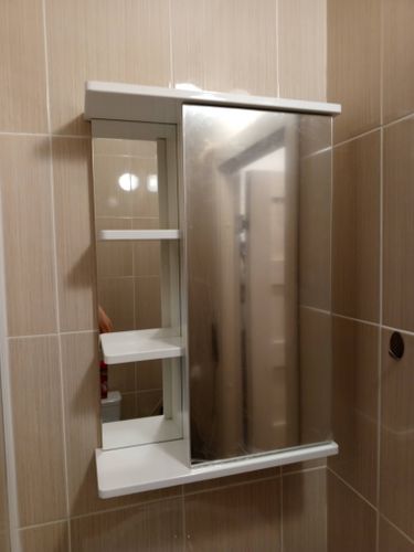 Установлен зеркальный шкаф на стену в ванной комнате. Надежно закреплены крепления, выровнена конструкция. Проверена устойчивость и функциональность дверей и полок.