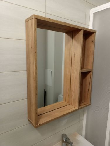 Завершено крепление зеркала в деревянной раме на стену ванной комнаты. Установлены надежные крепежи, обеспечивающие устойчивость и безопасность конструкции.