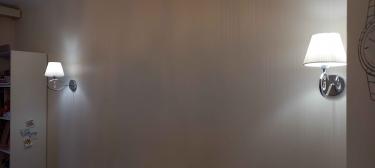 На стене закреплены два светильника. Проведено подключение к электросети, выполнено выравнивание и фиксация. Установлены лампы, проверена работоспособность, обеспечено равномерное освещение.