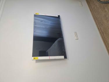 Телевизор аккуратно снят со стены, крепления демонтированы, провода отсоединены, поверхность очищена от следов установки, все элементы упакованы для безопасной транспортировки.