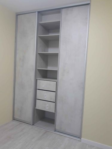 Собран шкаф с полками и выдвижными ящиками, установлены раздвижные двери. Конструкция выполнена аккуратно, обеспечивая функциональность и стильный внешний вид.