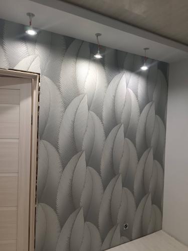 Стены оклеены стеклохолстом с узором, создающим текстурный эффект. Поверхность ровная, без видимых швов, обеспечена аккуратная подгонка рисунка. Освещение подчеркивает рельеф.