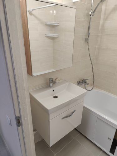 В ванной комнате установлен новый смеситель. Проведены работы по подключению к водопроводу, проверена герметичность соединений, обеспечена функциональность и эстетичность установки.