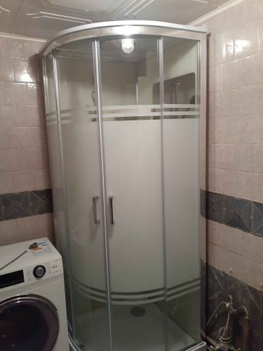 Установлена новая душевая кабина с прозрачными дверями, заменены коммуникации, обновлена плитка на стенах, подключены сантехнические элементы, обеспечена герметичность и функциональность.