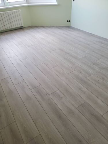 Панели уложены ровно, без зазоров, на подготовленное основание. Подложка обеспечивает звукоизоляцию. Покрытие гармонично сочетается с интерьером, создавая уютную атмосферу.