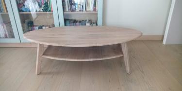 Собран овальный деревянный стол с полкой. Все детали соединены, конструкция устойчива, поверхность ровная. Готов к использованию в интерьере.