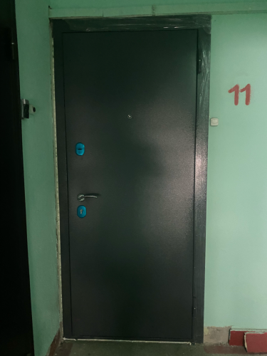 Дверь покрыта панелями из МДФ, что придаёт ей современный вид и улучшает звукоизоляцию. Установлены новые ручки и замки, обеспечивающие безопасность и комфорт.