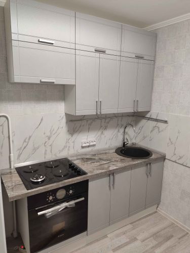 Установлена кухонная поверхность с вырезами под варочную панель и мойку. Все элементы точно подогнаны, обеспечивая функциональность и эстетичный вид.