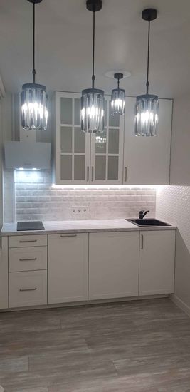 Установлены шкафы, смонтирована столешница, врезана мойка, подключена варочная панель, закреплены ручки, повешены светильники, выполнена облицовка фартука плиткой, подключены розетки.